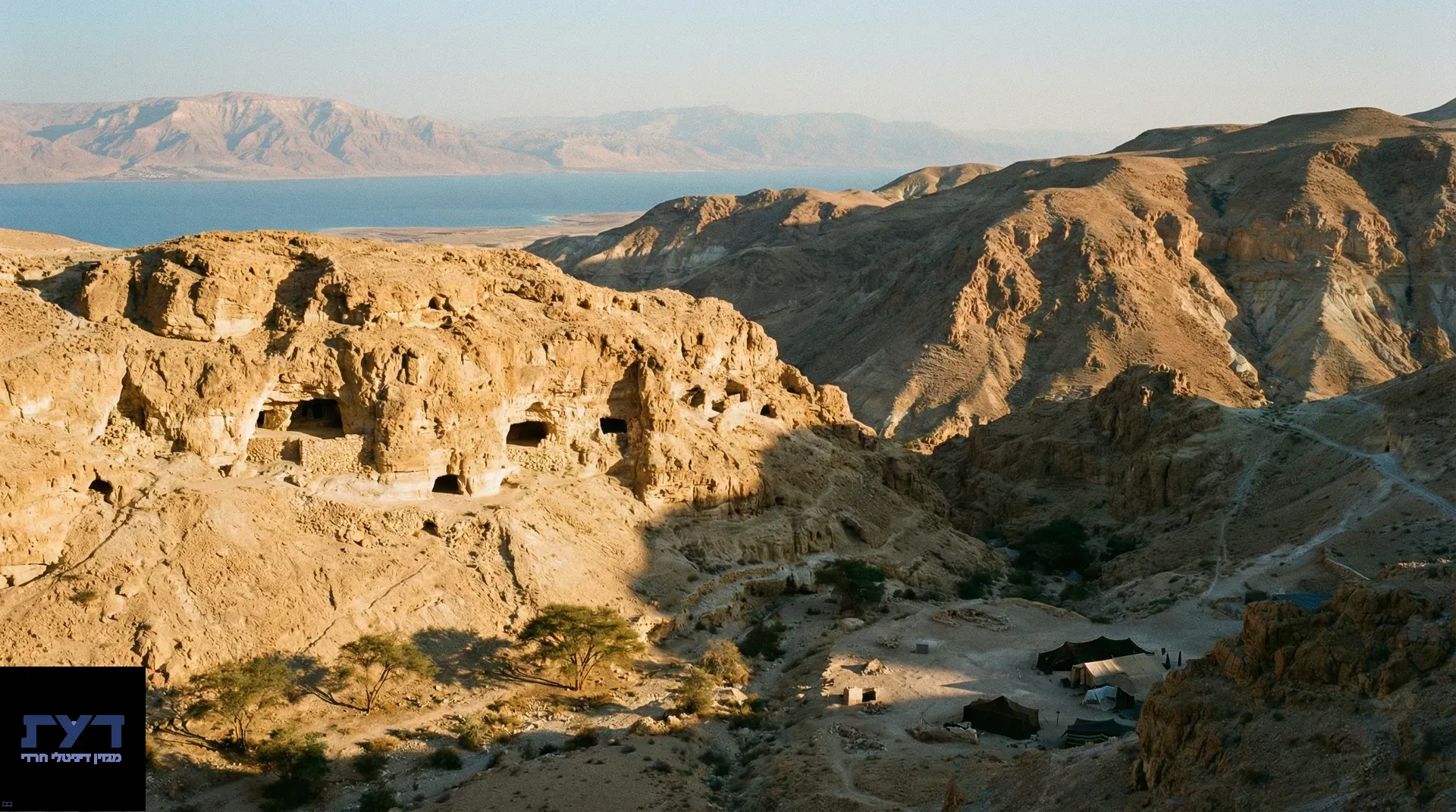 מערות עתיקות בצוק מדבר חום מול ים המלח, נוף פנורמי של הרי יהודה עם צמחייה ירוקה בעמק