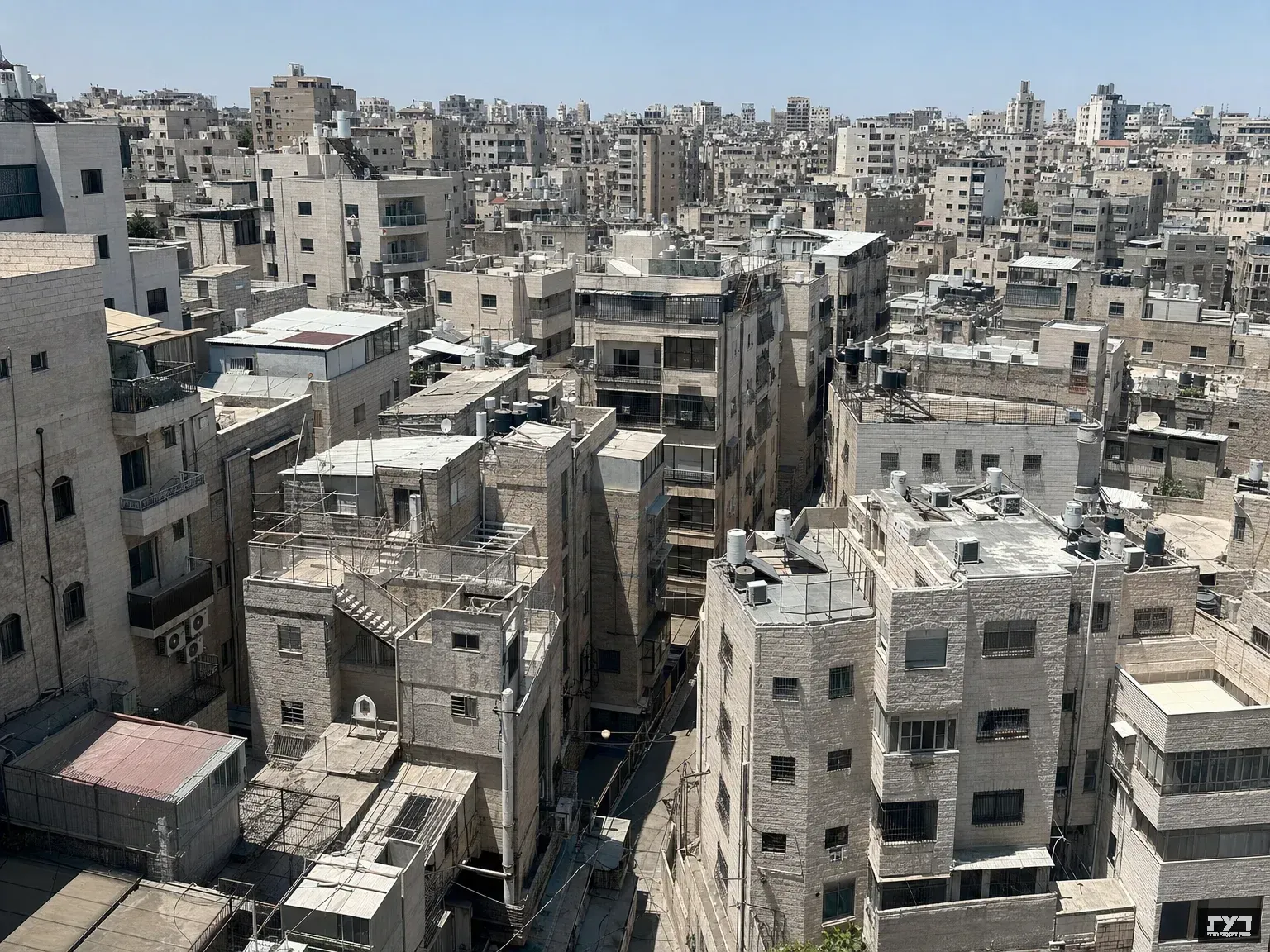 מבט אווירי על שכונת מגורים צפופה עם בניינים גבוהים וסמטאות צרות